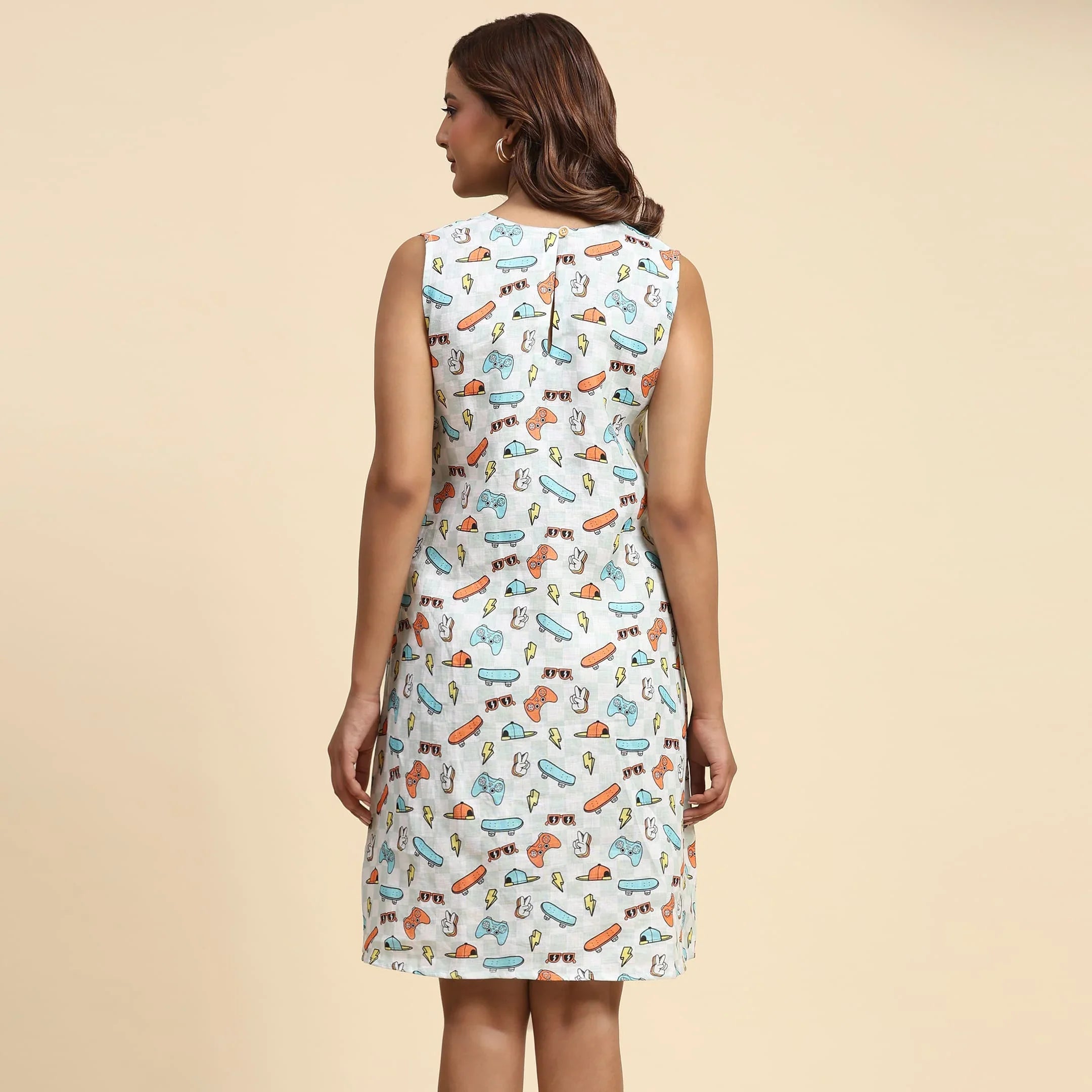 Woman wearing sleeveless white dress with colorful quirky print, viewed from the back