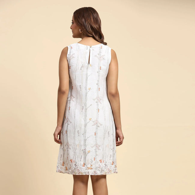 Woman wearing sleeveless white printed dress, back view, on beige background