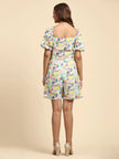 Woman wearing colorful abstract print romper with puff sleeves, shown from the back