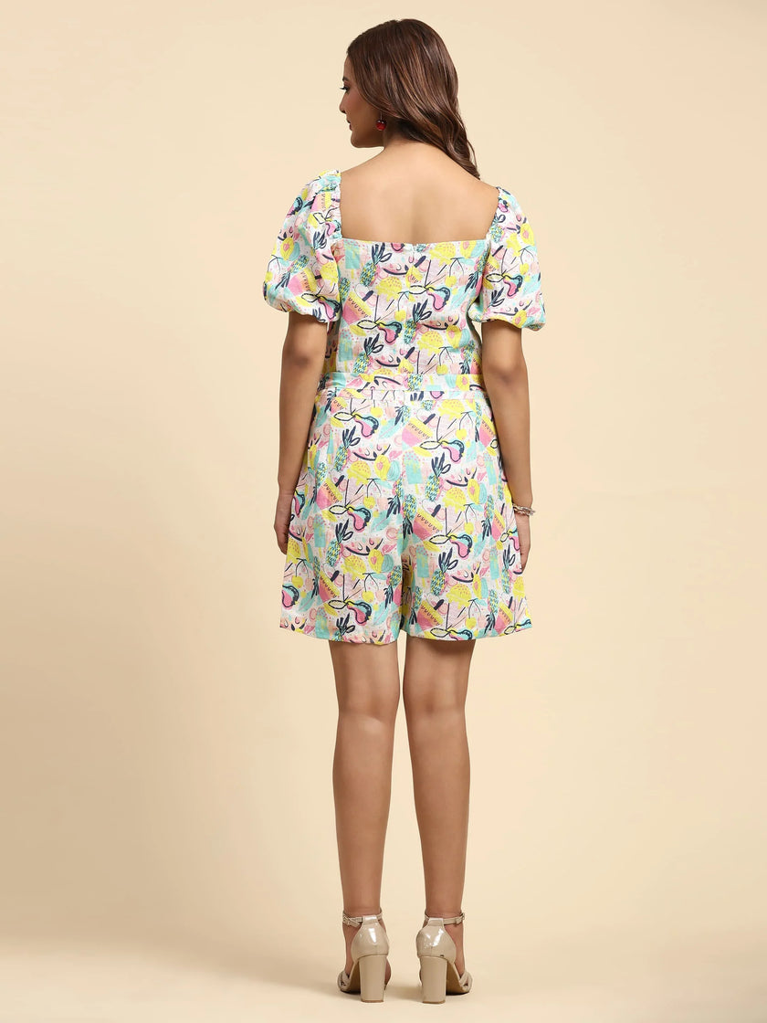 Woman wearing colorful abstract print romper with puff sleeves, shown from the back