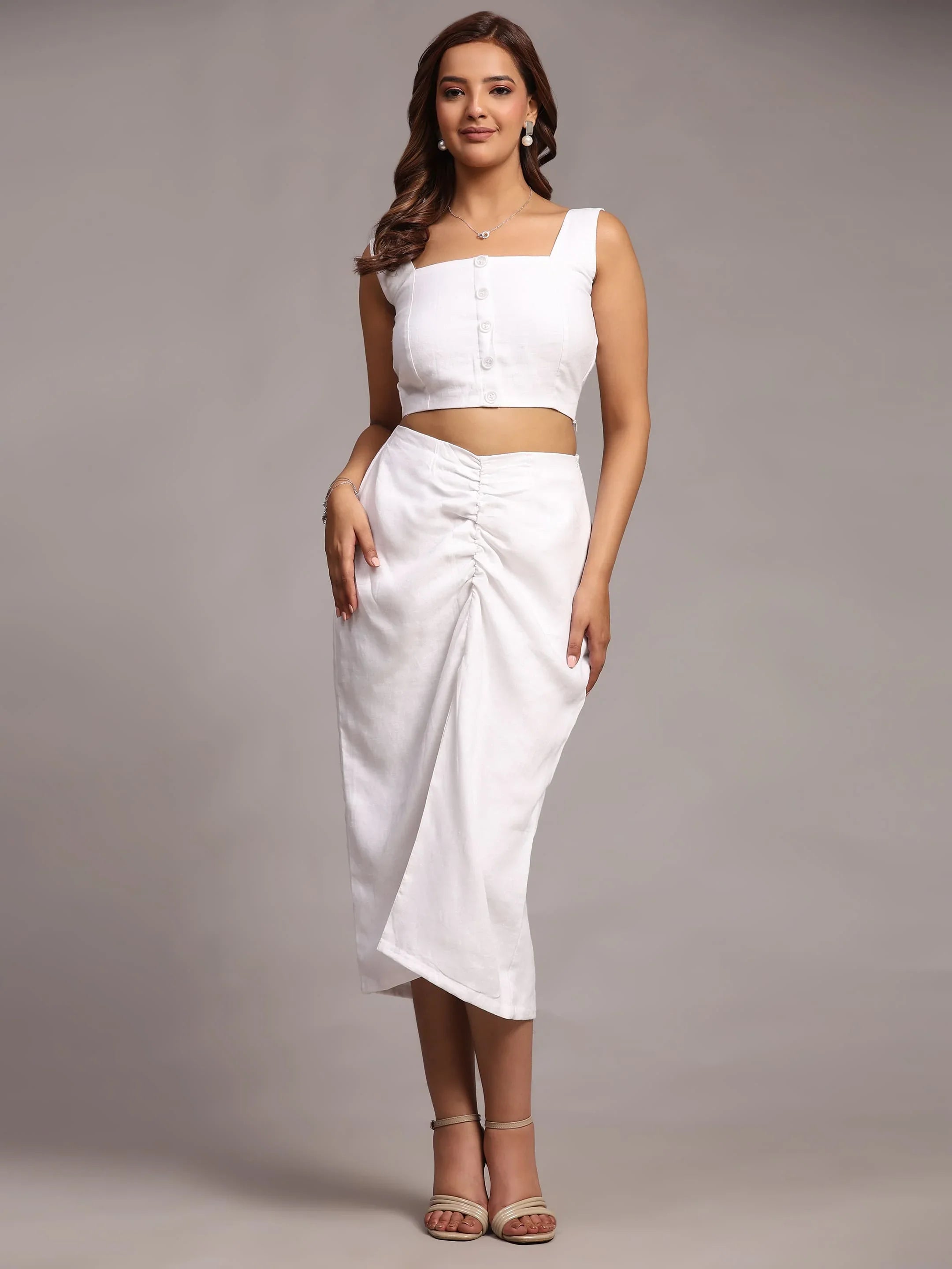 Woman wearing a stylish white crop top and ruched midi skirt, modern adult fashion outfit