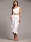 Woman wearing a stylish white crop top and ruched midi skirt, modern adult fashion outfit