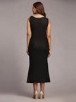 Woman in sleeveless black midi dress and beige heels, shown from the back, studio setting