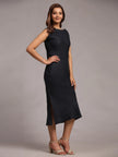 Woman modeling elegant sleeveless black midi dress with side slit and nude heels