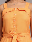 Close-up of woman wearing an orange sleeveless belted dress with front buttons and a necklace