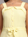 Light yellow sleeveless dress with button front and waist tie bow, close-up view