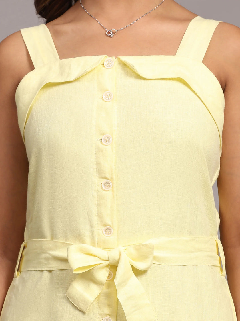 Light yellow sleeveless dress with button front and waist tie bow, close-up view