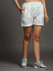 Woman wearing pastel printed shorts with pockets and blue sneakers, fashion studio shot