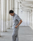 Man wearing grey two-piece casual set in a modern, industrial hallway