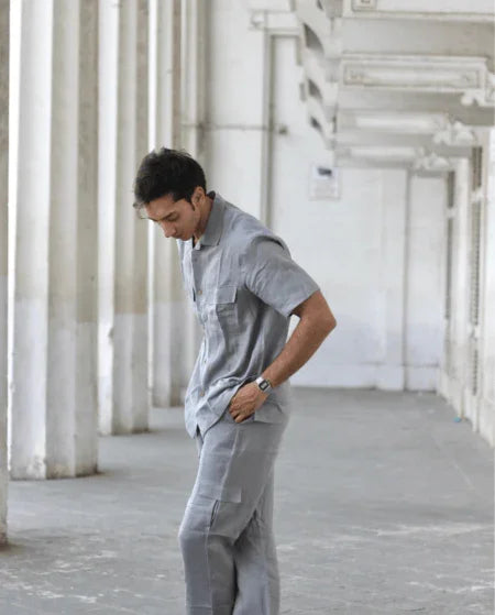 Man wearing grey two-piece casual set in a modern, industrial hallway