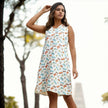 Woman outdoors in a sleeveless white dress with colorful, playful all-over print.
