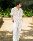 Man outdoors in short-sleeve patterned shirt and white cargo pants, casual fashion